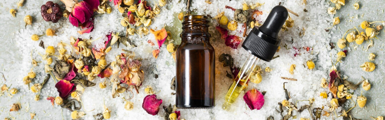 Foto suggestiva di una boccetta con contagocce vista dall'alto su fiori, petali e vegetali, ingredienti tipici della Fitoterapia. Nello studio medico LEOZONE, la Fitoterapia è utilizzata per la prevenzione e la cura delle malattie.